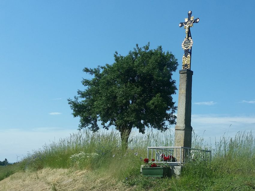 Historisches Wegkreuz neben einem Baum