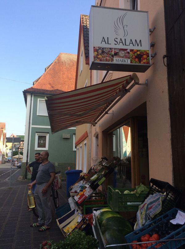 Außenansicht eines Lebensmittelgeschäftes mit Obst- und Gemüseauslagen