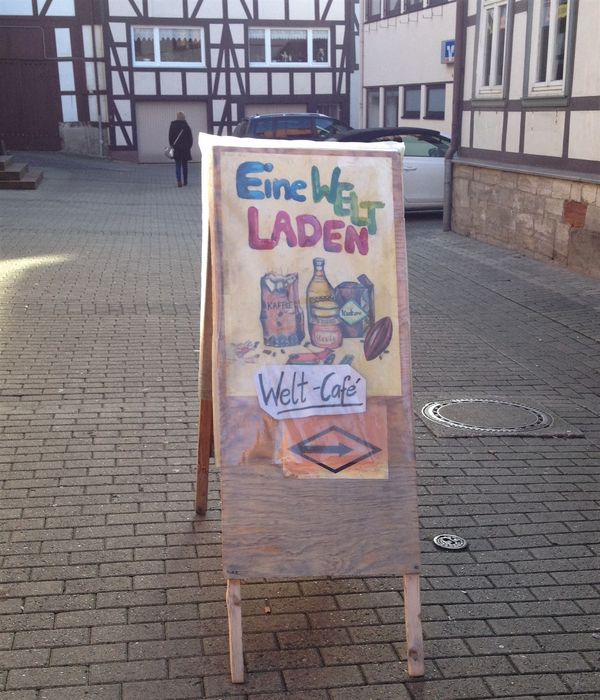 Hinweisschild auf "Eine Welt Laden" und auf das "Welt Cafe"